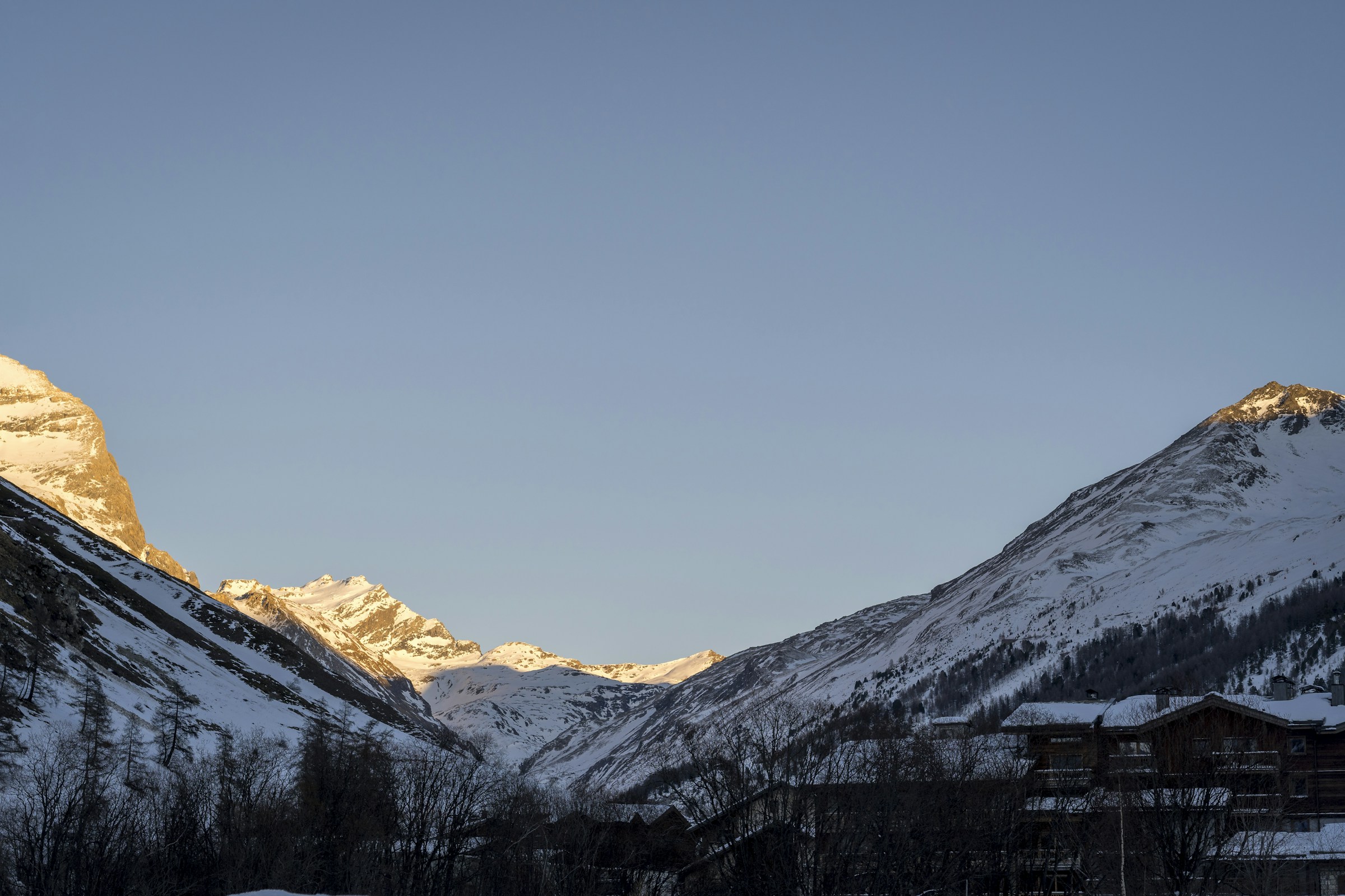 Chalets de Val d’Isère au pied des montagnes enneigées dans la lumière d’hiver